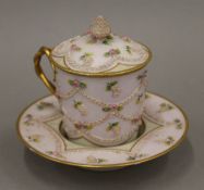 A 19th century Continental porcelain chocolate cup, cover and saucer. 12.5 cm high.