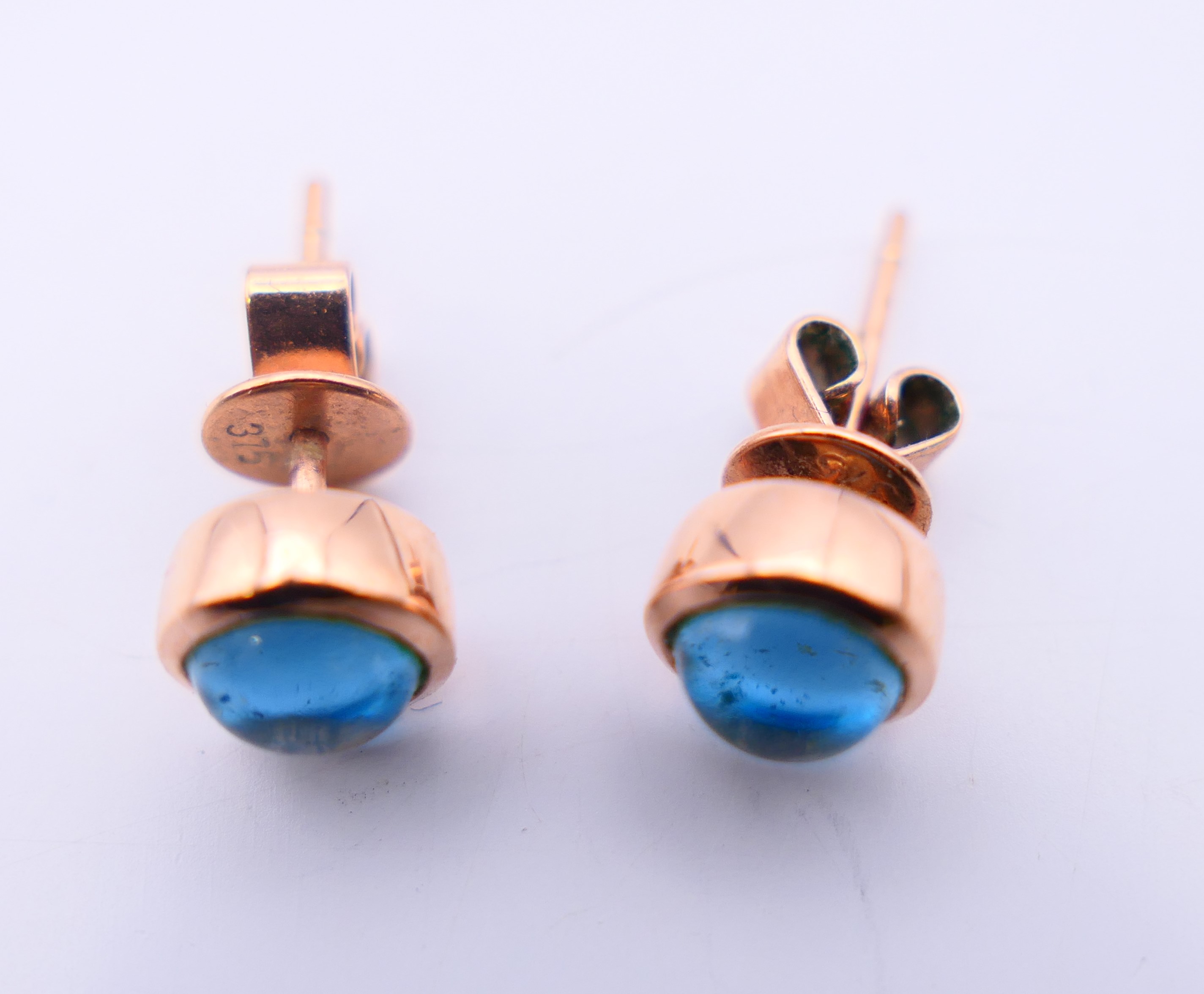 A pair of 9 ct rose gold earrings set with star cut/cabochon topaz gemstones. 0.5 cm diameter. - Image 4 of 6