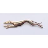 A silver brooch in the form of a greyhound. 7 cm long.