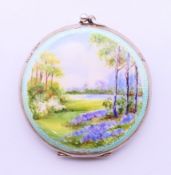A silver and enamel decorated compact. 5 cm diameter.