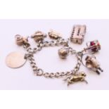 A silver charm bracelet and charms. Approximately 20 cm long. 75.6 grammes total weight.