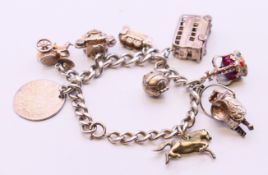 A silver charm bracelet and charms. Approximately 20 cm long. 75.6 grammes total weight.