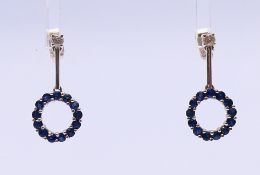 A pair of 18 ct white gold, diamond and sapphire drop earrings. 2 cm high.