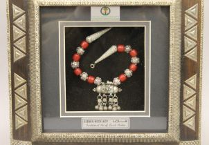 A boxed, framed Bedouin necklace. The box 30 cm wide.