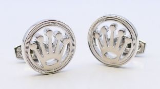 A pair of cufflinks, stamped Rolex, in a Harrods box. 2 cm diameter.