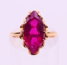 A 10 k gold and red stone (possibly ruby) ring. Ring size L.