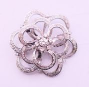 An 18 ct white gold and diamond brooch. 3.5 cm diameter.
