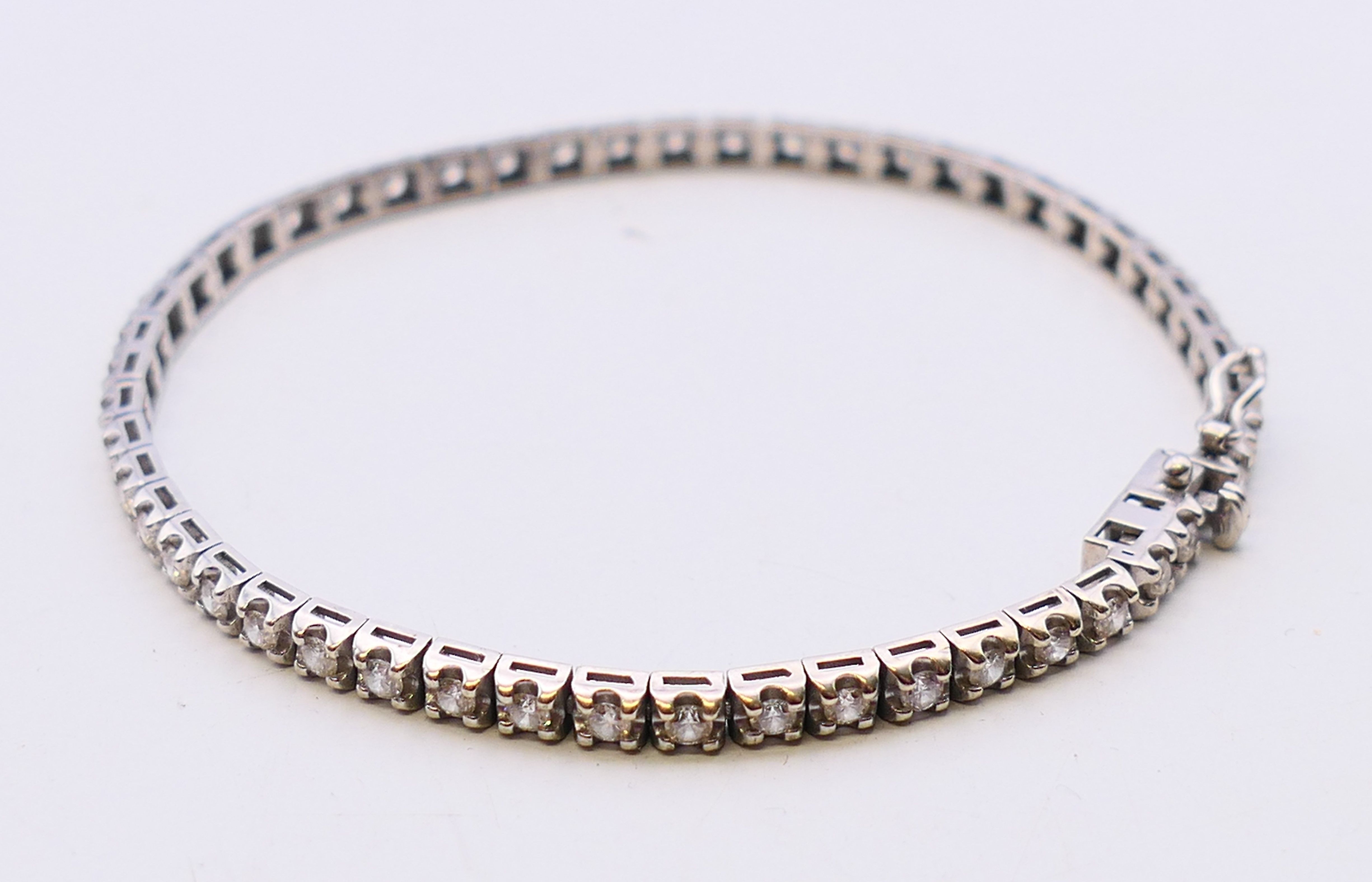 A white gold and diamond line bracelet. 18 cm long.