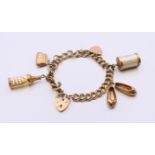 A 9 ct gold bracelet with padlock with five 9 ct gold charms. Approximately 18 cm long. 26.