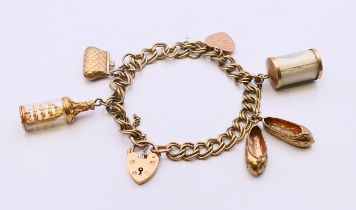 A 9 ct gold bracelet with padlock with five 9 ct gold charms. Approximately 18 cm long. 26.