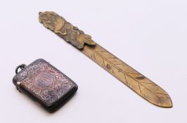 A silver vesta and a Japanese brass letter knife. Vesta 4.5 cm x 3.5 cm, knife 15.5 cm long.