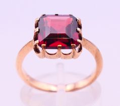 An unmarked, possibly 18 ct gold and garnet ring. Ring size L/M.