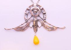 A silver Art Nouveau-style winged female head and bead pendant on a silver chain.