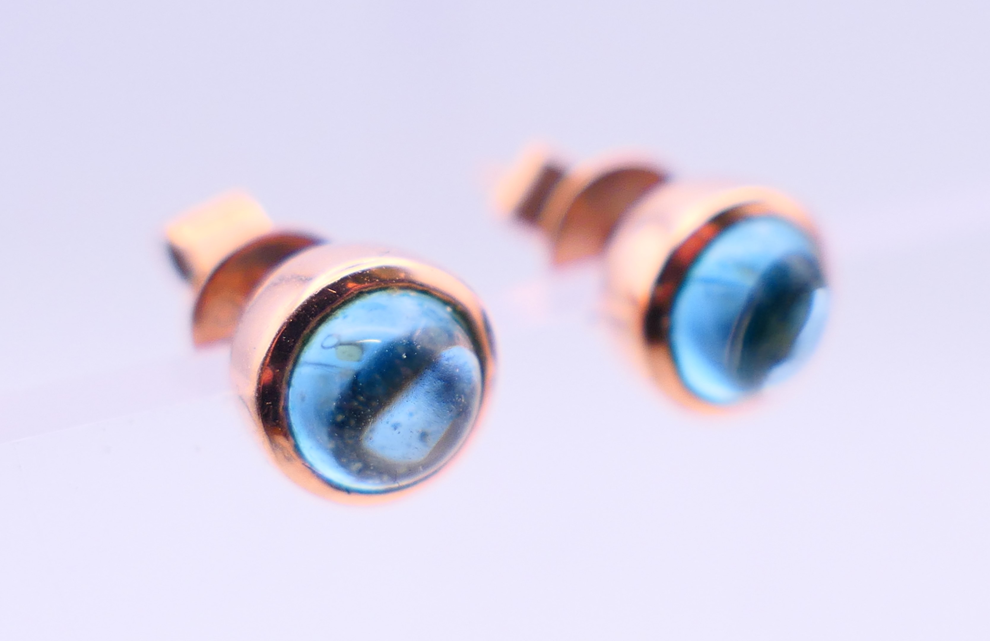 A pair of 9 ct rose gold earrings set with star cut/cabochon topaz gemstones. 0.5 cm diameter. - Image 2 of 6