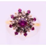 An 18 ct gold, ruby and diamond cluster set ring. Ring size M.