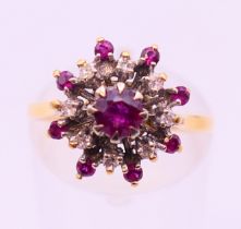 An 18 ct gold, ruby and diamond cluster set ring. Ring size M.