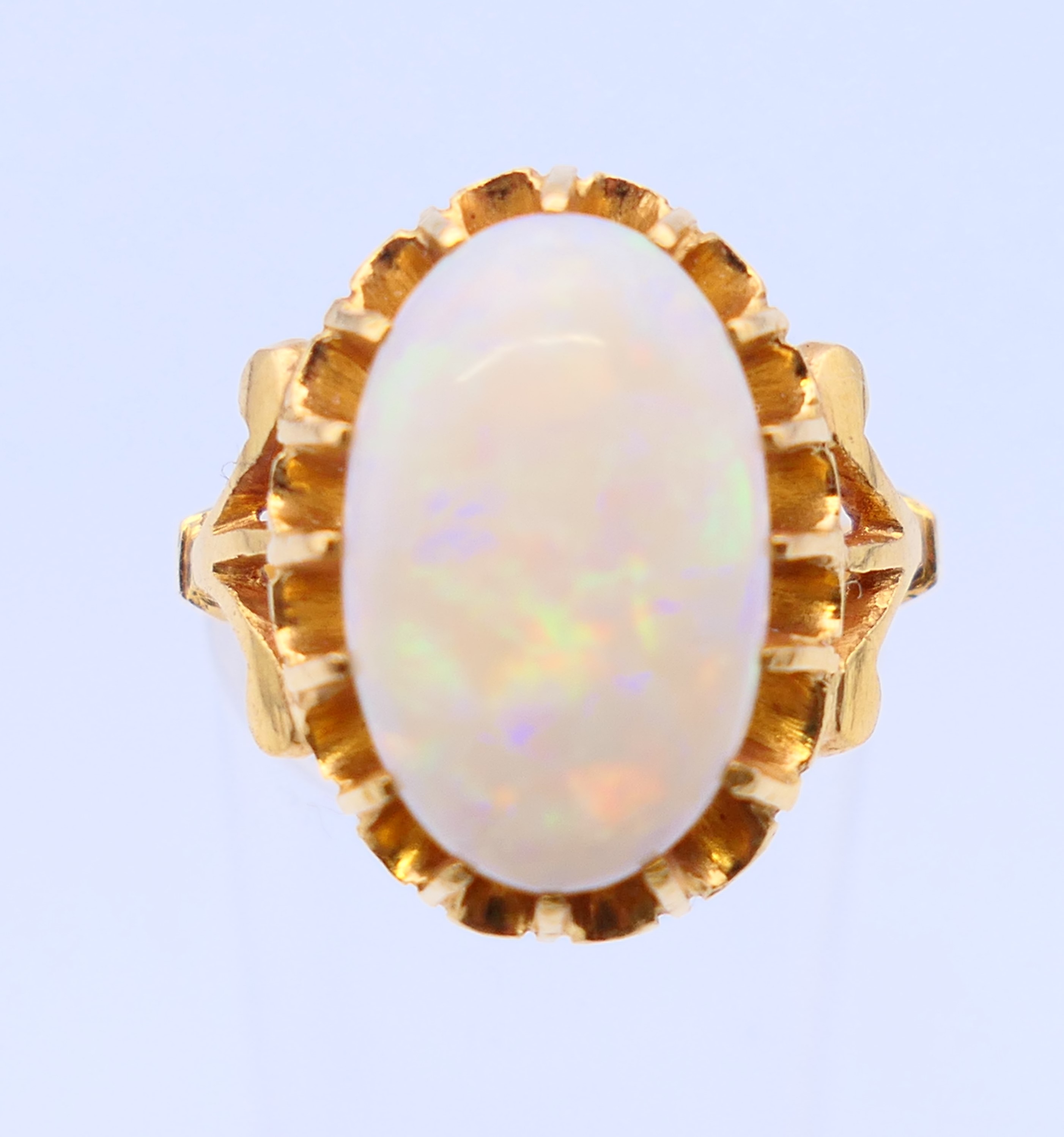 An unmarked 22 ct gold and opal ring. Ring size J.