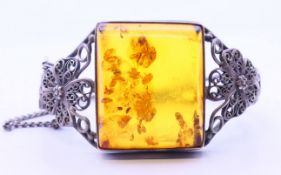 An "amber" white metal (tested silver) bracelet. 6 cm diameter.