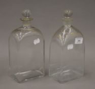 Two early 19th century glass and gilt decorated decanters with stoppers. The largest 26 cm high.