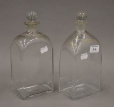 Two early 19th century glass and gilt decorated decanters with stoppers. The largest 26 cm high.