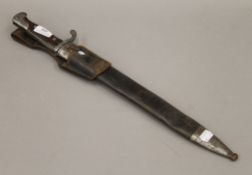 A bayonet in scabbard. 53 cm long.