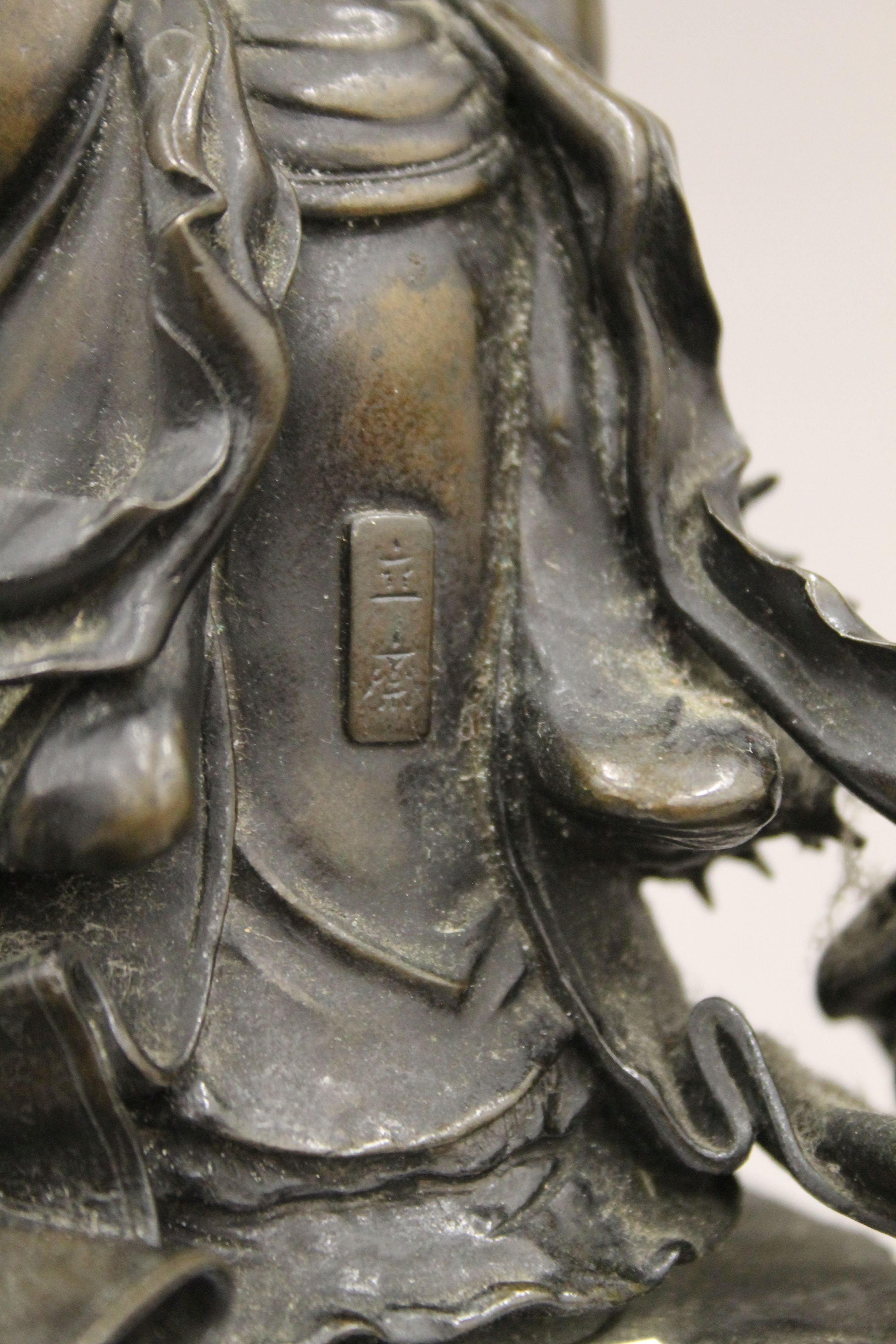 A 19th century Oriental bronze figure of Guanyin standing on a cast rockwork base with dragons. - Image 5 of 5