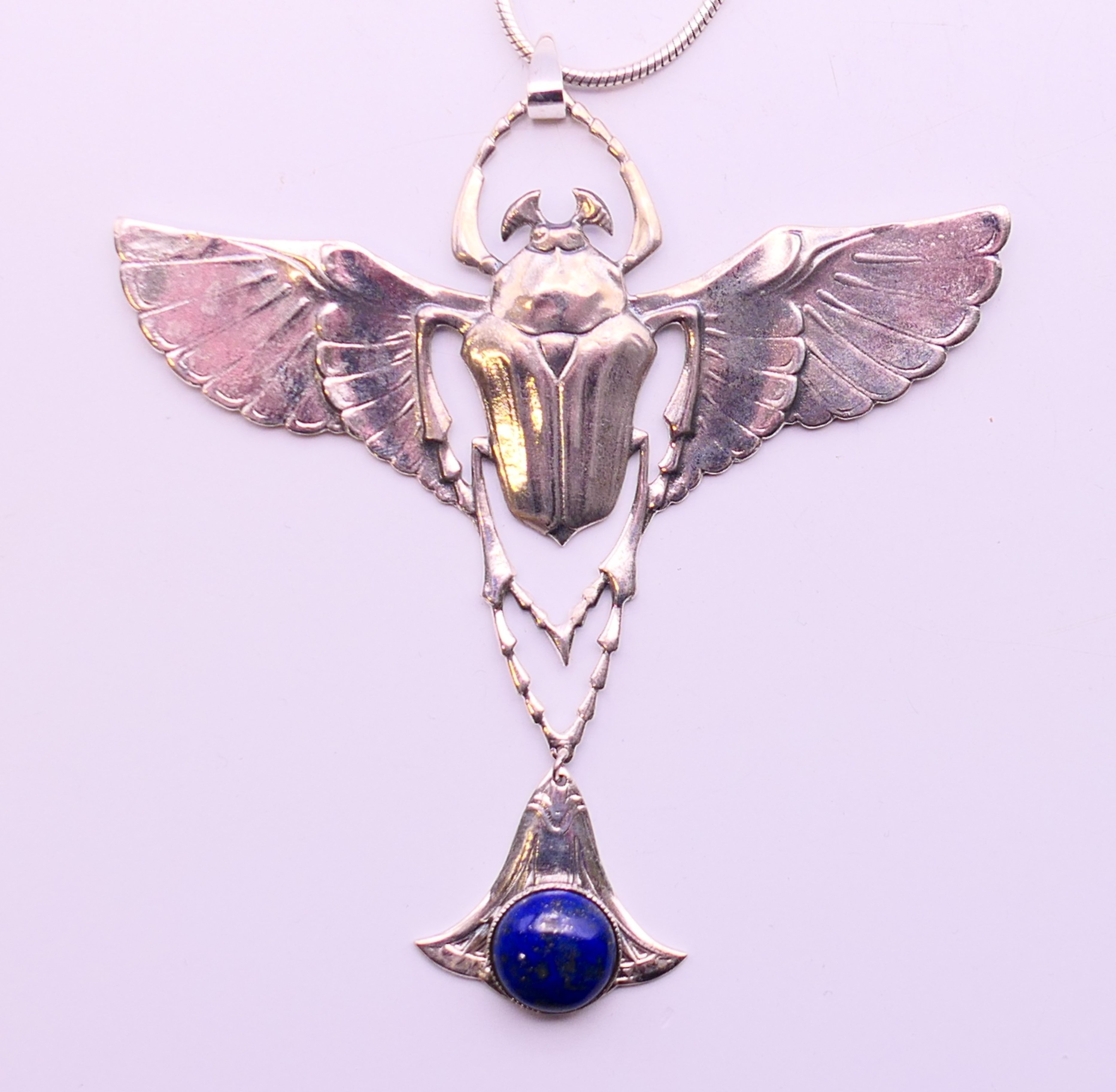 A silver and lapiz scarab pendant necklace. Pendant 9 cm high, chain 45 cm long.