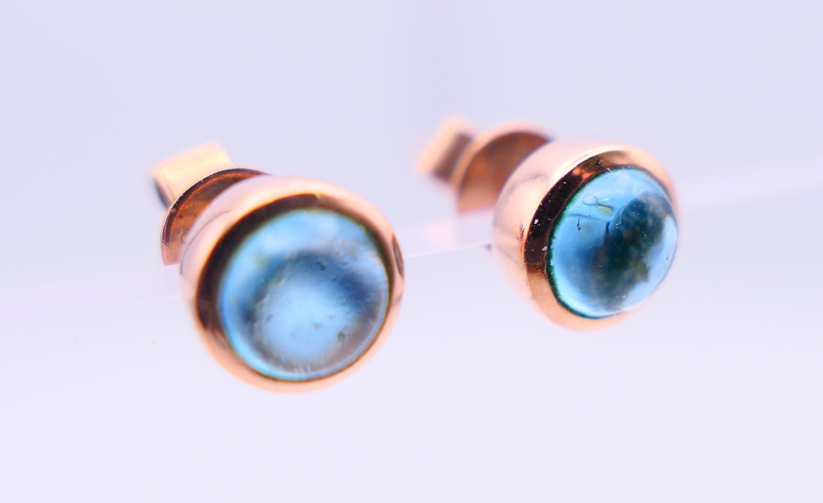 A pair of 9 ct rose gold earrings set with star cut/cabochon topaz gemstones. 0.5 cm diameter. - Image 3 of 6