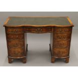 A mahogany serpentine-fronted pedestal desk. 115 cm long.