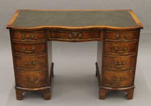 A mahogany serpentine-fronted pedestal desk. 115 cm long.