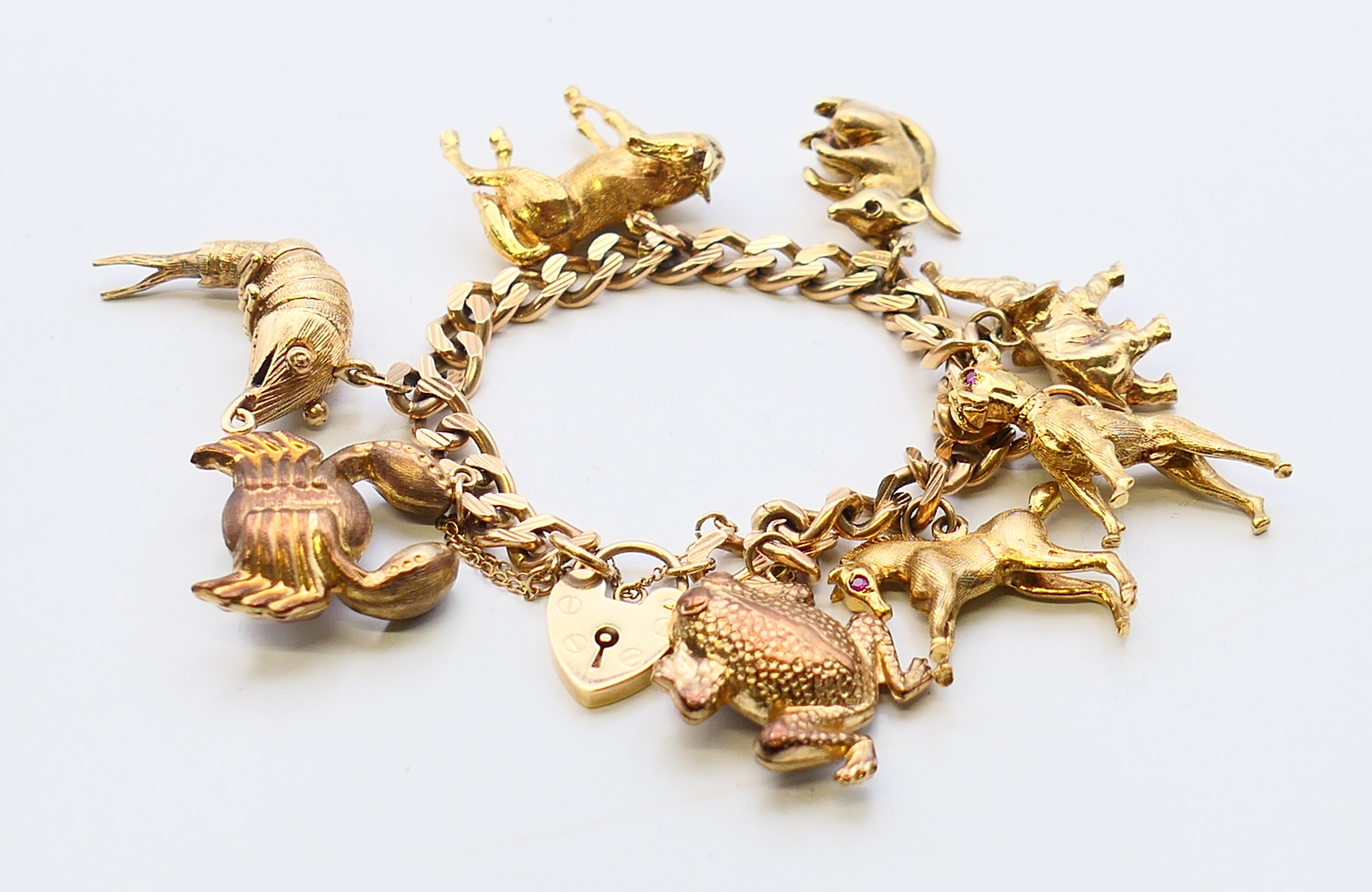 A 9 ct gold curb link bracelet with eight animal charms. 18 cm long. 60.
