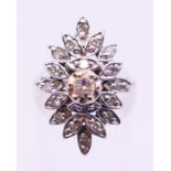 A platinum and diamond flowerhead ring. Ring size K/L.