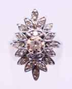 A platinum and diamond flowerhead ring. Ring size K/L.