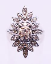 A platinum and diamond flowerhead ring. Ring size K/L.