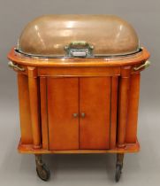 A copper-topped restaurant food warming trolley.