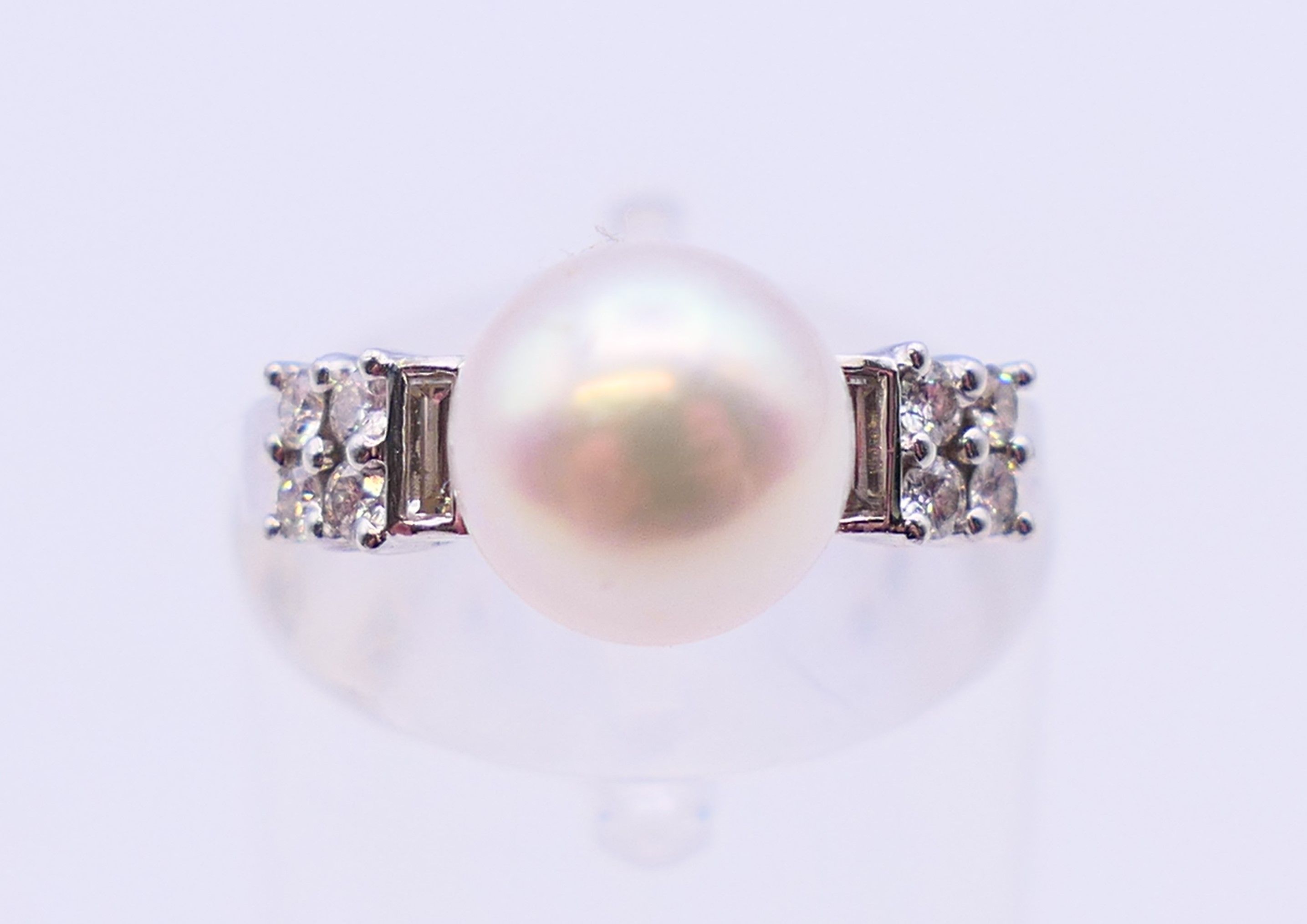 An 18 ct white gold and pearl ring flanked by baguette cut and round diamonds. Ring size I. - Image 2 of 6