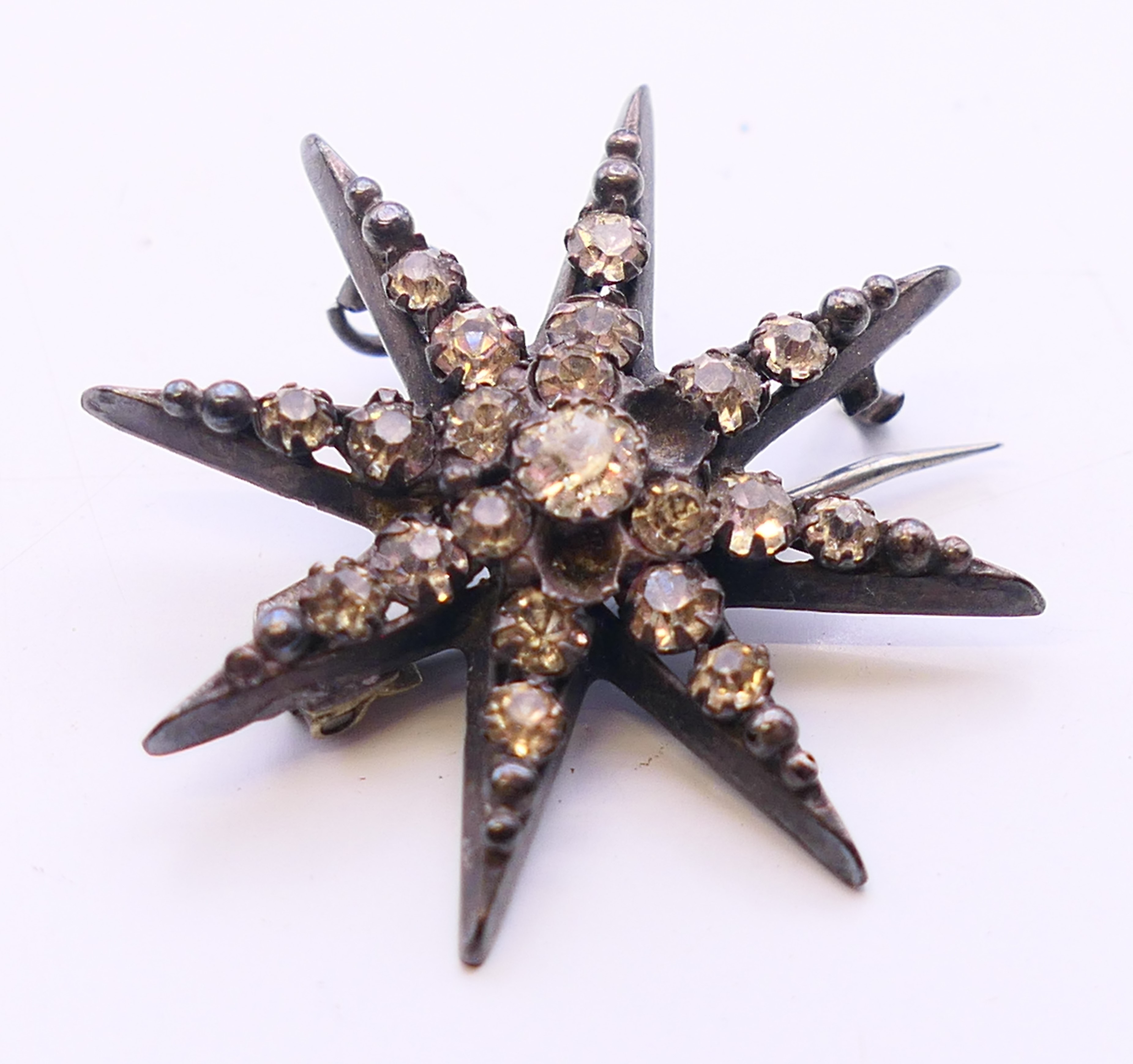 A small quantity of costume jewellery to include two necklaces and a star form brooch. Brooch 3. - Image 7 of 11