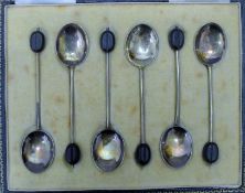 A cased set of enamel and silver coffee spoons. The case 16 cm wide. 46.6 grammes total weight.