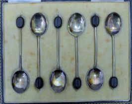 A cased set of enamel and silver coffee spoons. The case 16 cm wide. 46.6 grammes total weight.