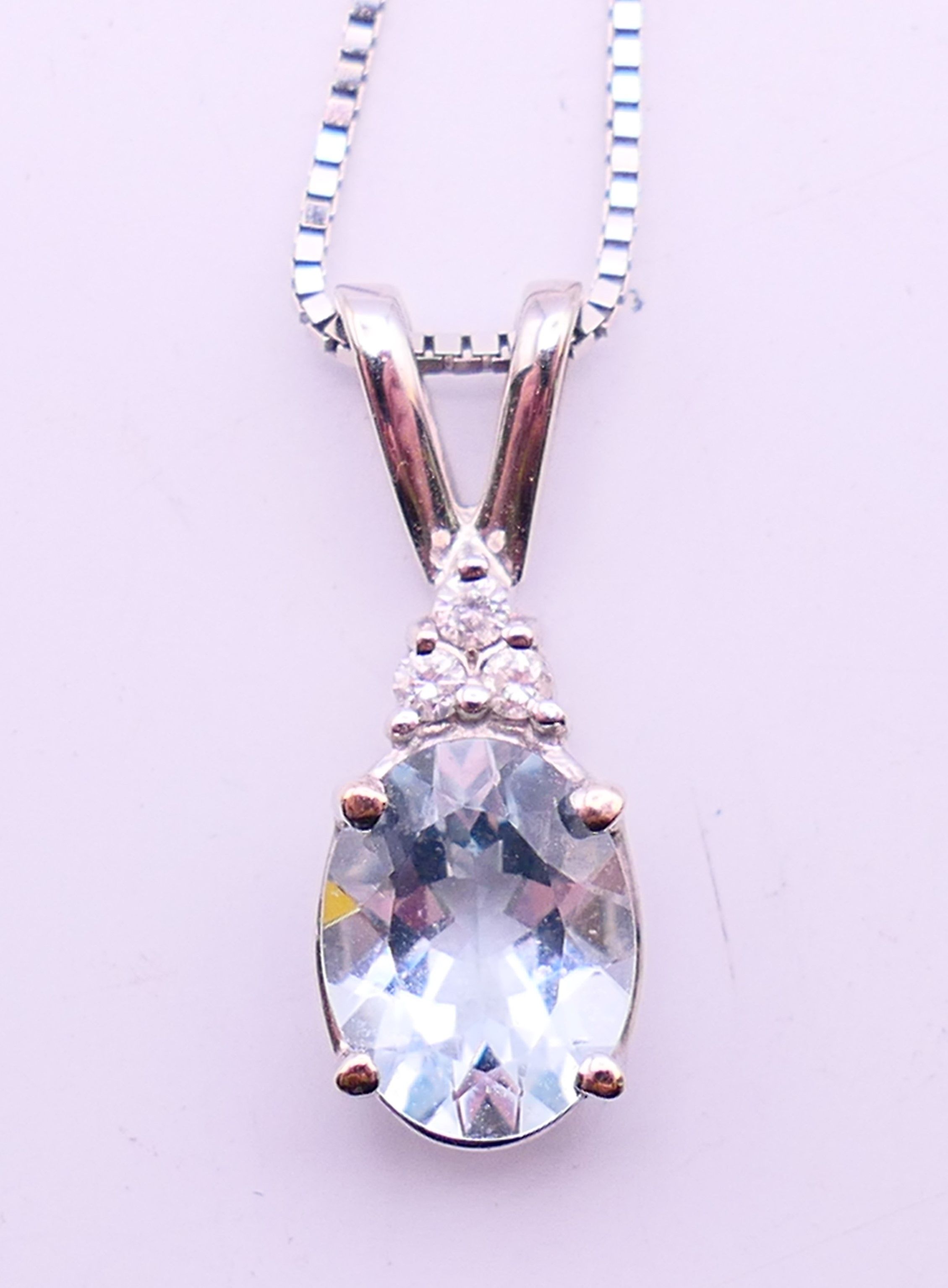 A 14 ct white gold aquamarine diamond pendant on a 14 K white gold chain.
