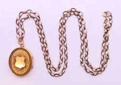 A Victorian locket on a 9ct gold chain. Locket 3 cm high, chain 60 cm long. 15.