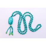 A string of turquoise beads with a turquoise pendant.