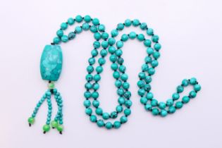 A string of turquoise beads with a turquoise pendant.
