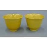 A pair of Chinese yellow ground porcelain cups. Each 5.75 cm high.