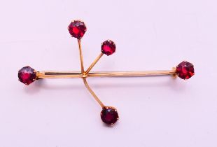 A 9 ct gold five stone circular garnet constellation brooch (garnets 3.6-4.3mm) with metal pin. 4.