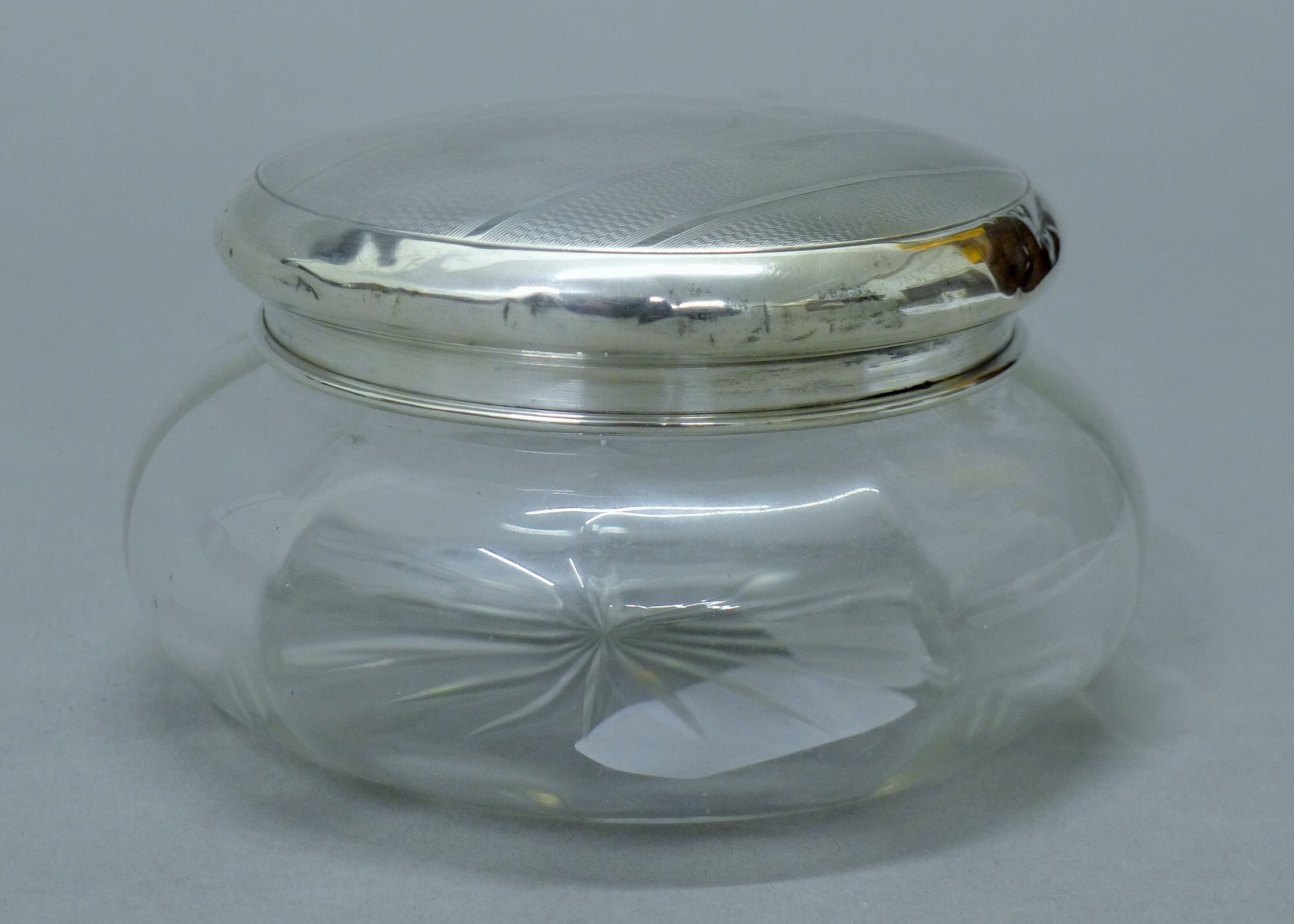 A glass dressing table jar with silver lid. 12.5 cm diameter. 43.1 grammes of silver. - Image 2 of 4