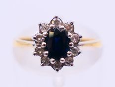An 18 ct gold sapphire cluster ring. Ring size K.