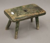 An 18th/19th century milking stool with some green painted decoration. 26.5 cm long.
