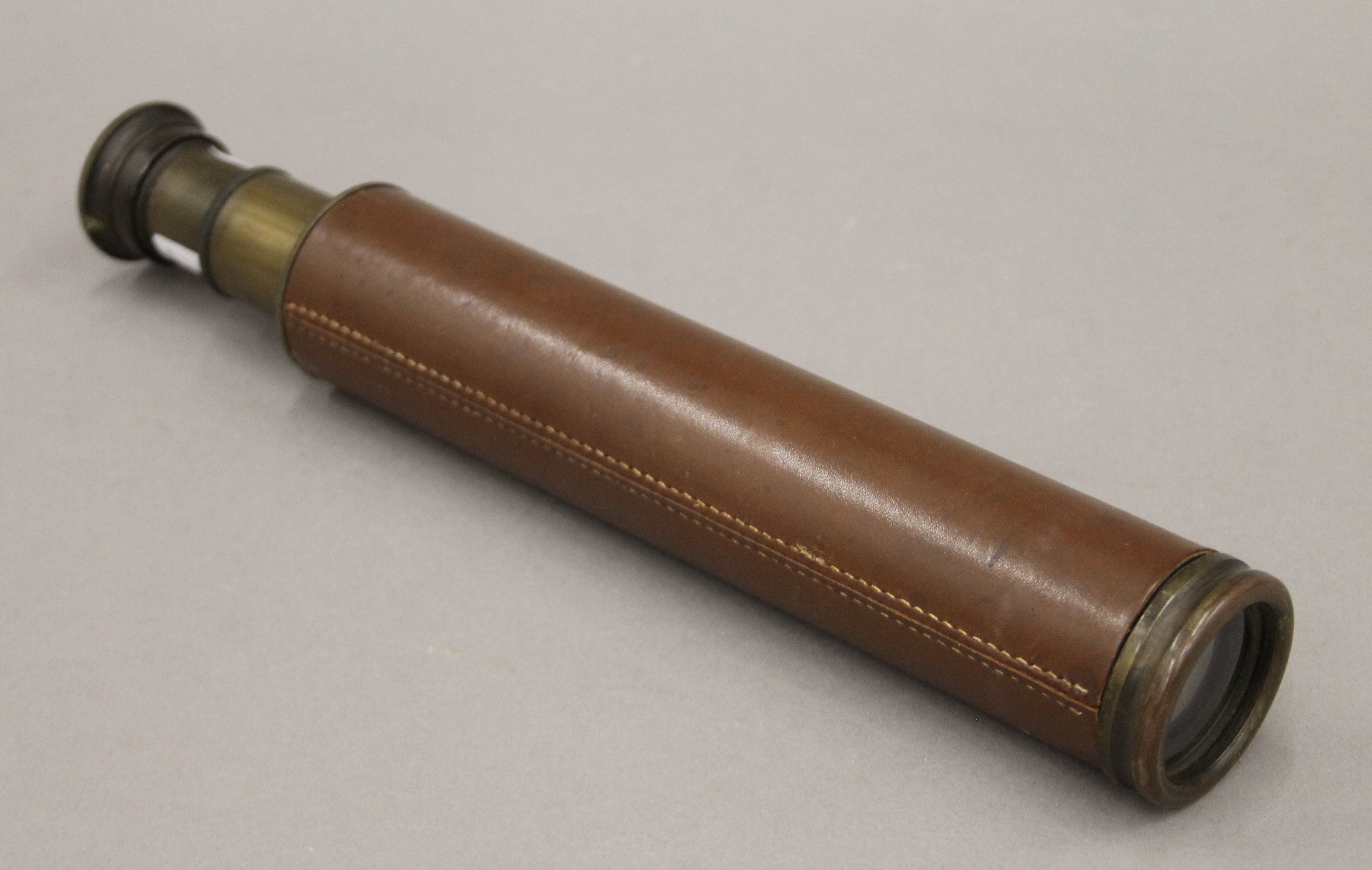 A leather-bound brass three-draw telescope, stamped Rangers Enbeeco, London. 69 cm long extended.