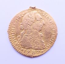 A 1787 gold Escudo coin. 1.75 cm diameter. 2.1 grammes.